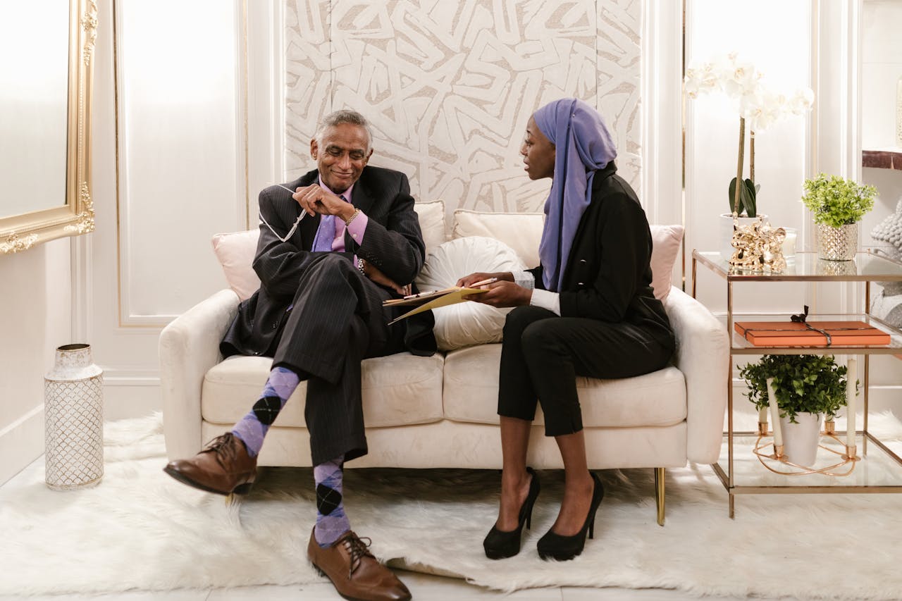 A man and woman engage in professional discussion in an elegant indoor setting, highlighting diversity.